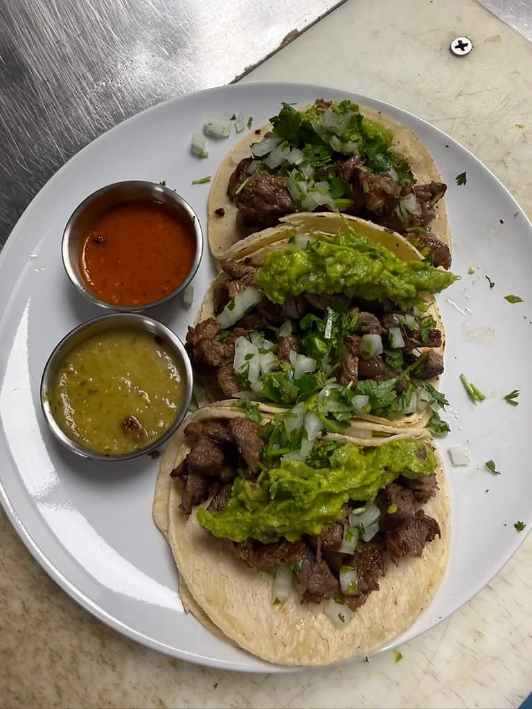 Carne asada street tacos topped with guacamole