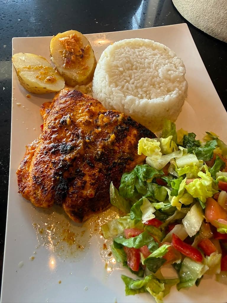 Grilled chicken plate with rice, roasted potatoes and salad
