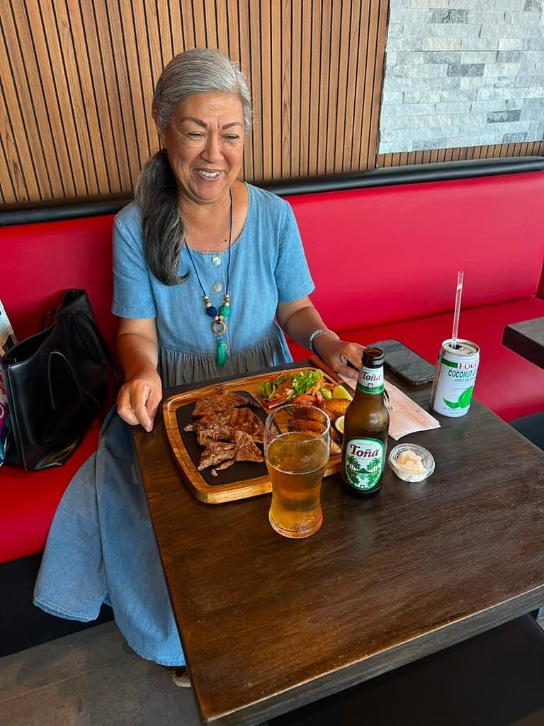 A guest enjoying a parrillada platter and a cold beer