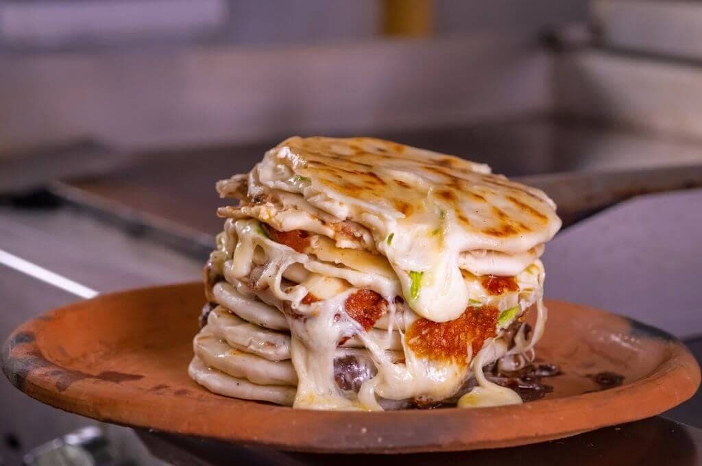 Stack of melted-cheese quesadillas on a clay plate